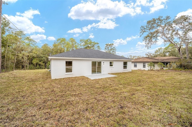 rear view of property with a lawn and a patio