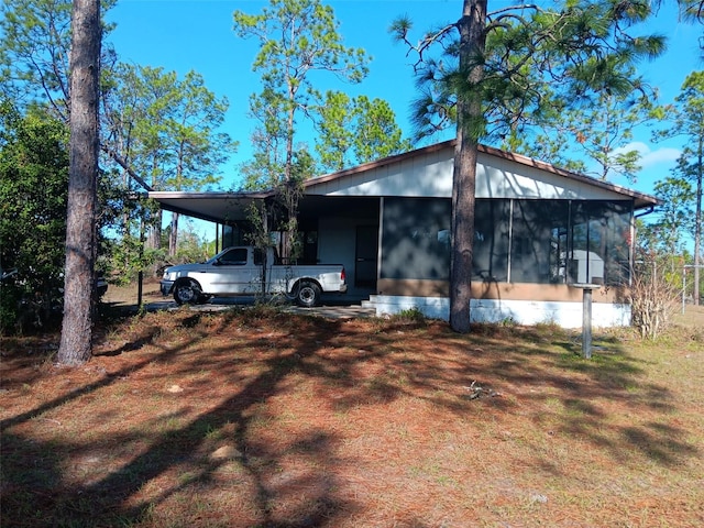 view of front of property featuring a sunroom and a carport