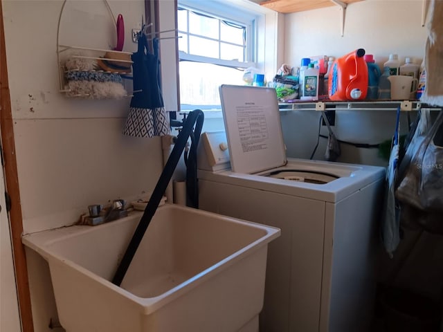 clothes washing area with washer / clothes dryer and sink