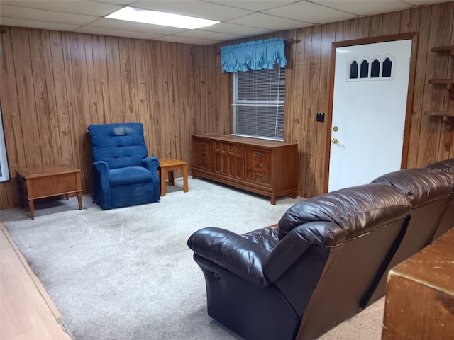 living room with a paneled ceiling and wooden walls