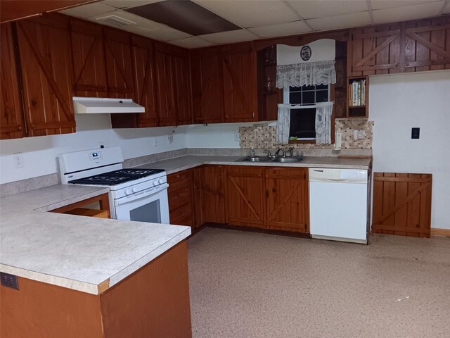 kitchen featuring sink, white appliances, a paneled ceiling, and kitchen peninsula