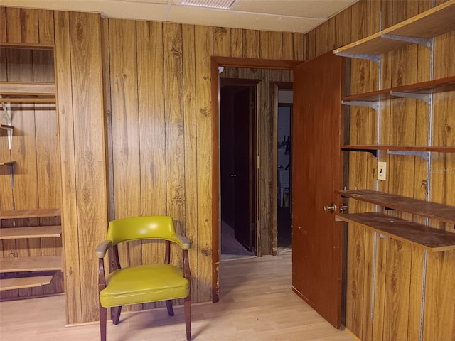 corridor featuring wooden walls and light hardwood / wood-style floors