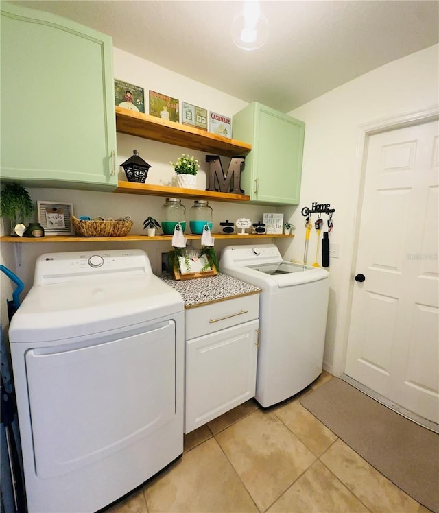 washroom featuring washer and dryer, light tile patterned flooring, and cabinets