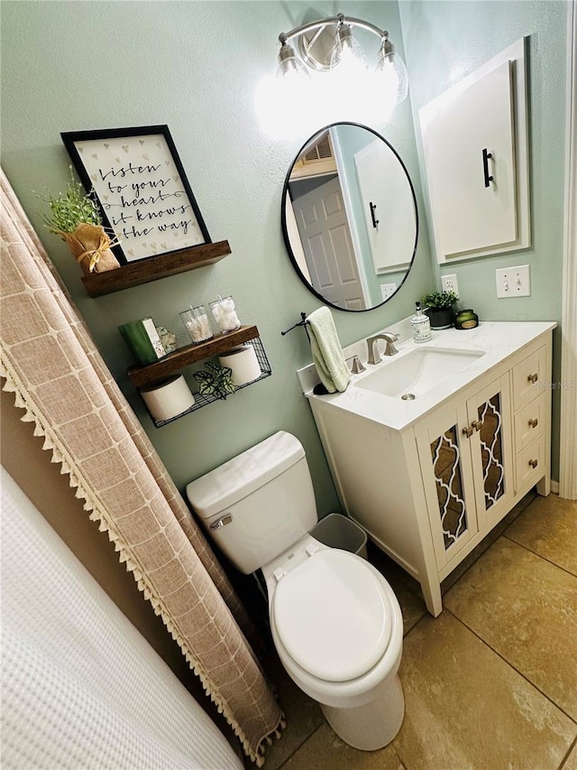 bathroom featuring tile patterned flooring, vanity, and toilet