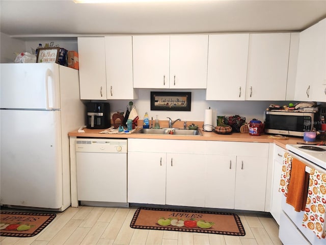 kitchen with white cabinetry, white appliances, and sink