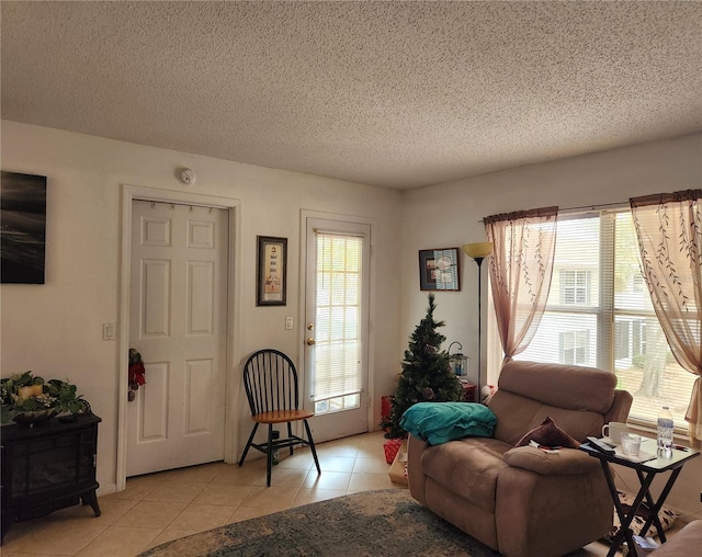 living room featuring a wealth of natural light, light tile patterned flooring, and a textured ceiling