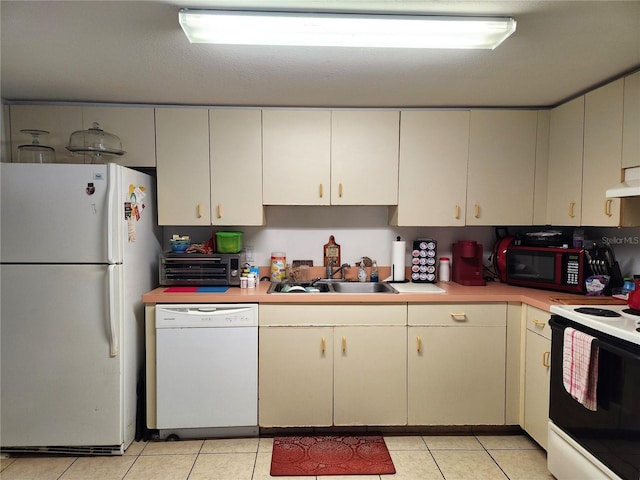 kitchen featuring range hood, sink, light tile patterned floors, and white appliances