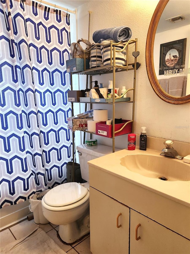 bathroom featuring toilet, vanity, and tile patterned floors