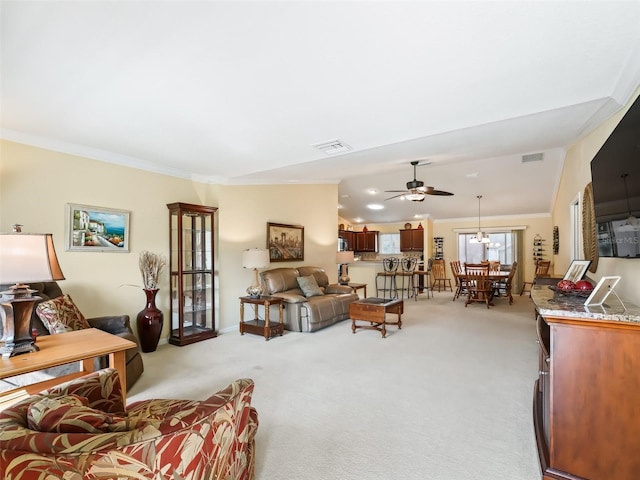 carpeted living room featuring ornamental molding and ceiling fan