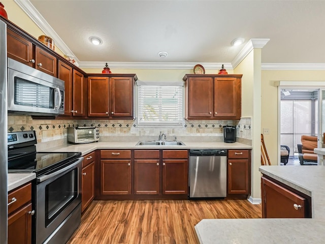 kitchen with sink, crown molding, decorative backsplash, and appliances with stainless steel finishes