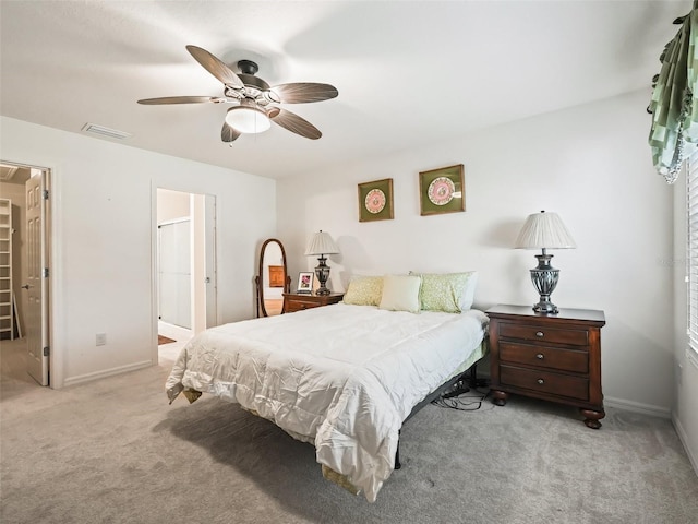 carpeted bedroom with connected bathroom and ceiling fan