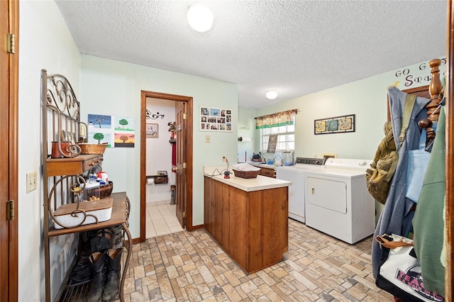 clothes washing area with a textured ceiling and separate washer and dryer