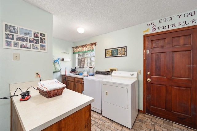 washroom featuring separate washer and dryer, cabinets, and a textured ceiling