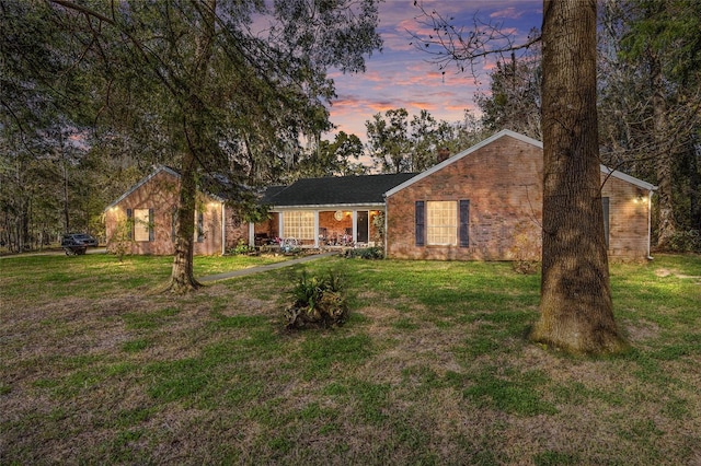 view of front of home featuring a front lawn and brick siding