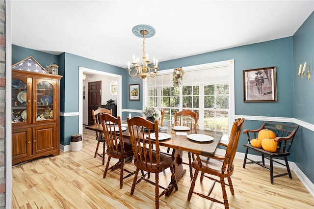 dining space featuring light hardwood / wood-style flooring and a chandelier