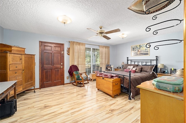 bedroom featuring ceiling fan, light hardwood / wood-style flooring, and a textured ceiling