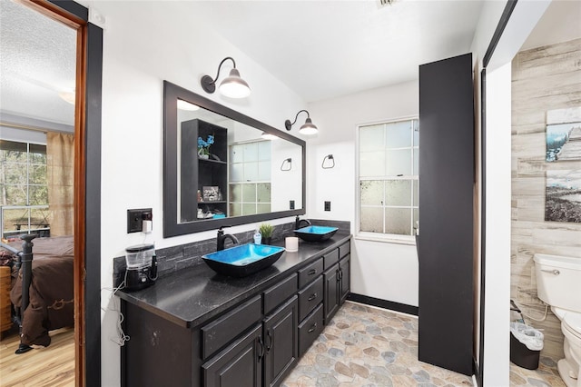 bathroom with vanity, a textured ceiling, and toilet