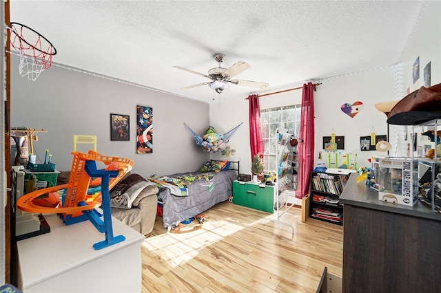 bedroom with ceiling fan, hardwood / wood-style floors, and a textured ceiling