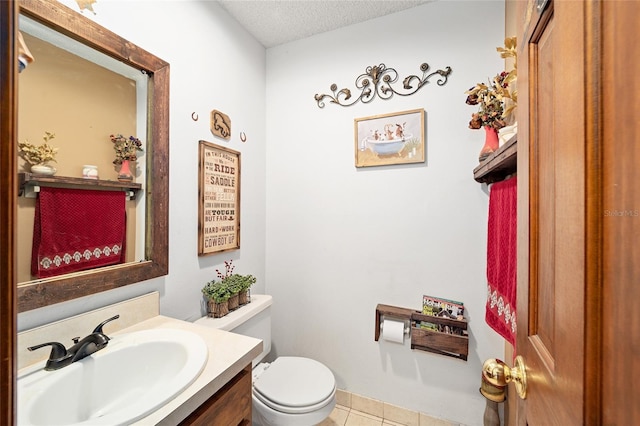 bathroom featuring toilet, vanity, a textured ceiling, and tile patterned floors