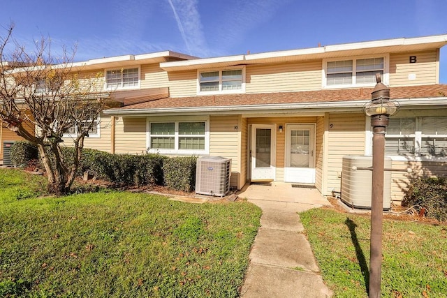 view of front of property with a front yard and central AC unit