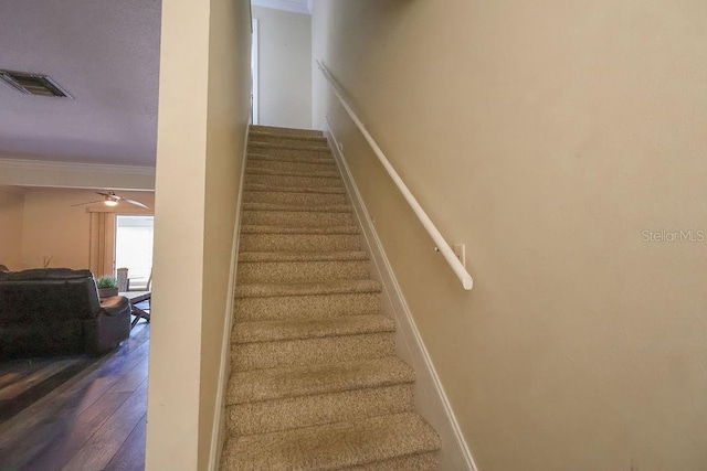 stairs with ceiling fan, ornamental molding, and wood-type flooring