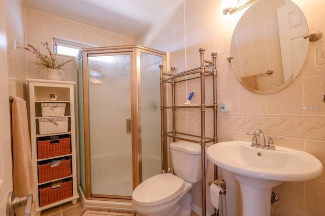 bathroom with tile walls, an enclosed shower, and toilet