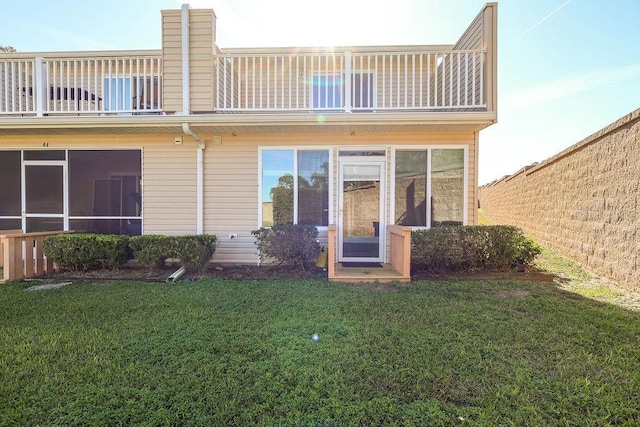 back of property featuring a yard and a balcony