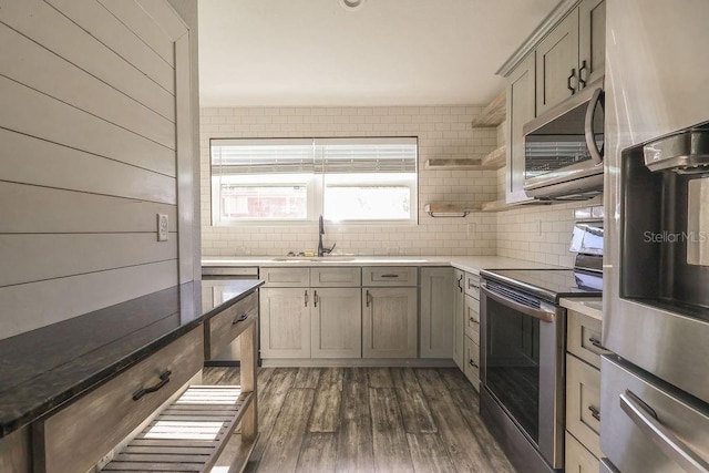 kitchen featuring stainless steel appliances, tasteful backsplash, sink, and dark hardwood / wood-style flooring