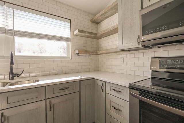 kitchen with tasteful backsplash, sink, stainless steel appliances, and light brown cabinetry