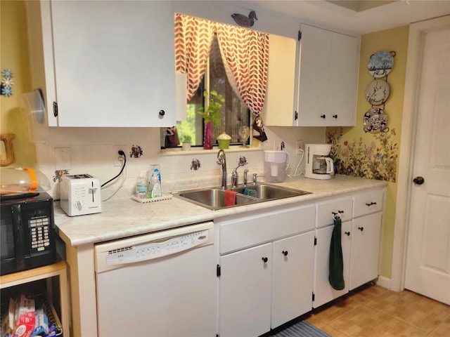 kitchen featuring dishwasher, white cabinetry, and sink