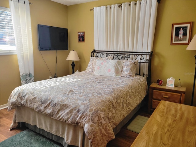 bedroom with dark wood-type flooring