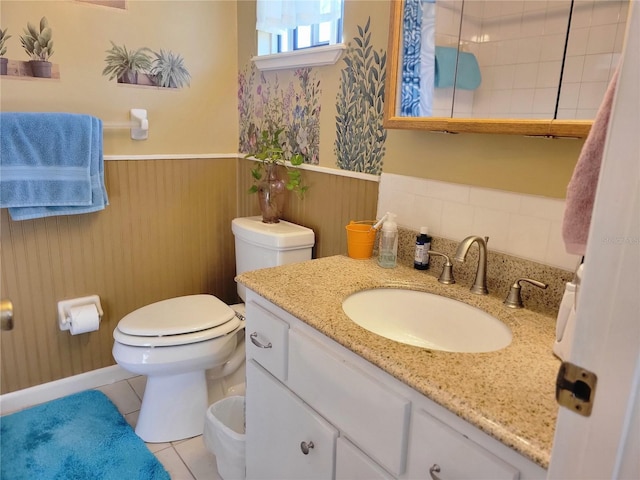 bathroom featuring toilet, vanity, tile patterned floors, and wooden walls