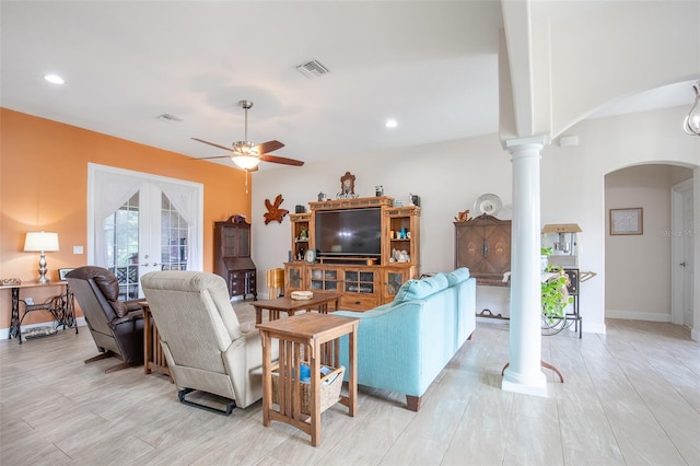 living room with visible vents, arched walkways, a ceiling fan, french doors, and ornate columns