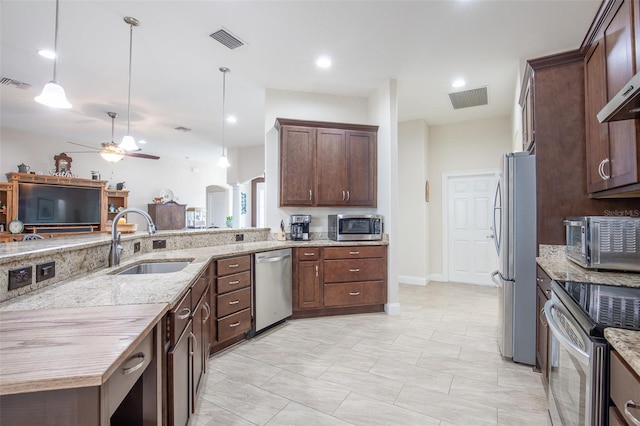 kitchen with appliances with stainless steel finishes, arched walkways, visible vents, and a sink