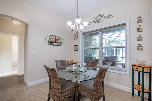 dining area with arched walkways, a notable chandelier, and baseboards