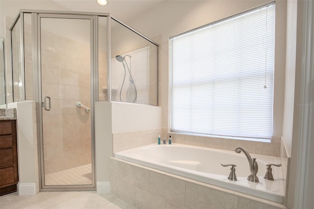 bathroom featuring a stall shower, tile patterned flooring, a bath, and vanity