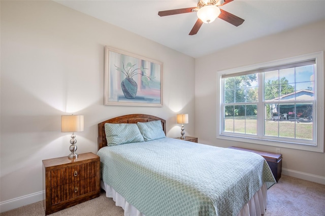 bedroom with baseboards, ceiling fan, and light colored carpet