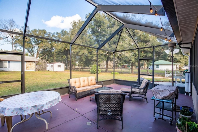 view of patio / terrace featuring glass enclosure, an outdoor structure, an outdoor living space, and a shed