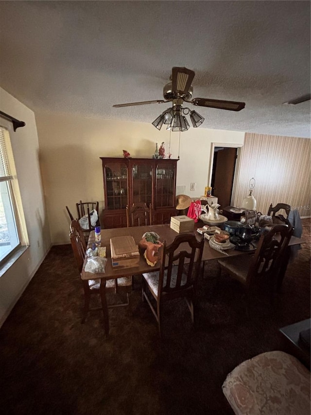 dining space with carpet floors, a textured ceiling, and a ceiling fan