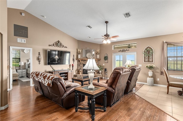 living room with hardwood / wood-style floors, ceiling fan, a healthy amount of sunlight, and vaulted ceiling