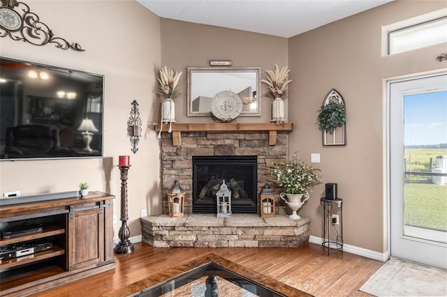 sitting room with a fireplace, hardwood / wood-style floors, and lofted ceiling