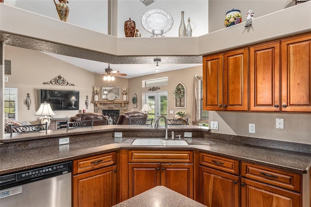 kitchen featuring french doors, stainless steel dishwasher, ceiling fan, sink, and a stone fireplace