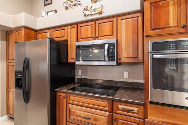 kitchen featuring dark stone countertops and stainless steel appliances