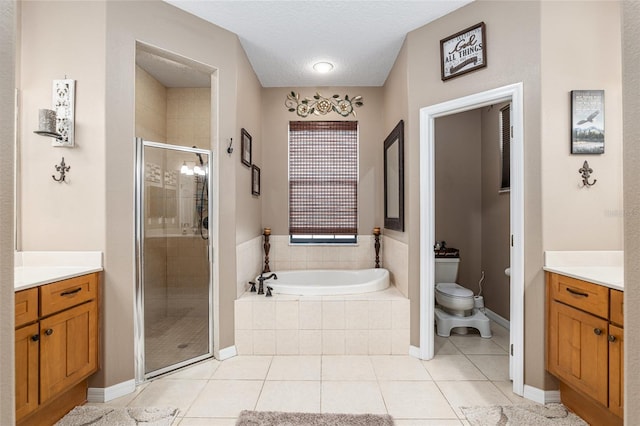 full bathroom featuring a textured ceiling, vanity, separate shower and tub, tile patterned flooring, and toilet