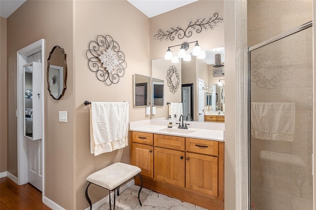 bathroom with a shower with door, vanity, and hardwood / wood-style floors