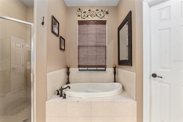 bathroom featuring independent shower and bath and a textured ceiling