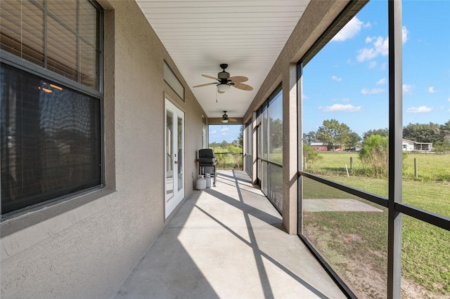 unfurnished sunroom featuring ceiling fan