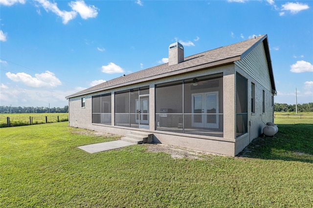 back of property featuring a sunroom and a lawn