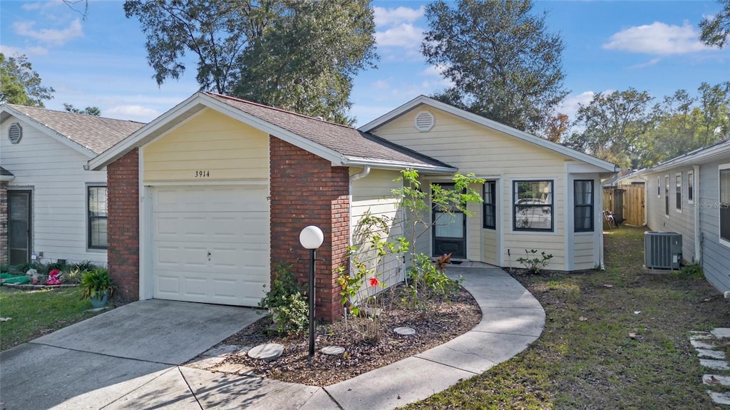 ranch-style house with cooling unit and a garage