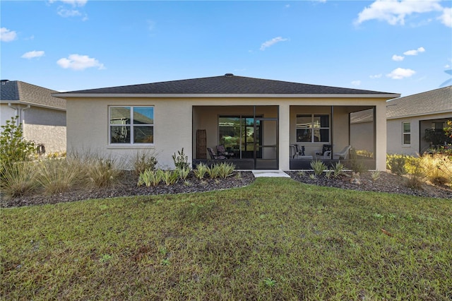 rear view of property featuring a lawn and a sunroom